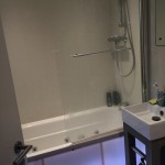 bath with shower head and lights on the base