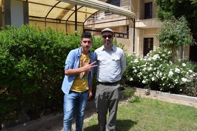 Aiden with a student in a garden in Iraq