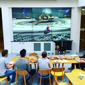 Big screen within the design studio used for playing Mario Kart at lunch